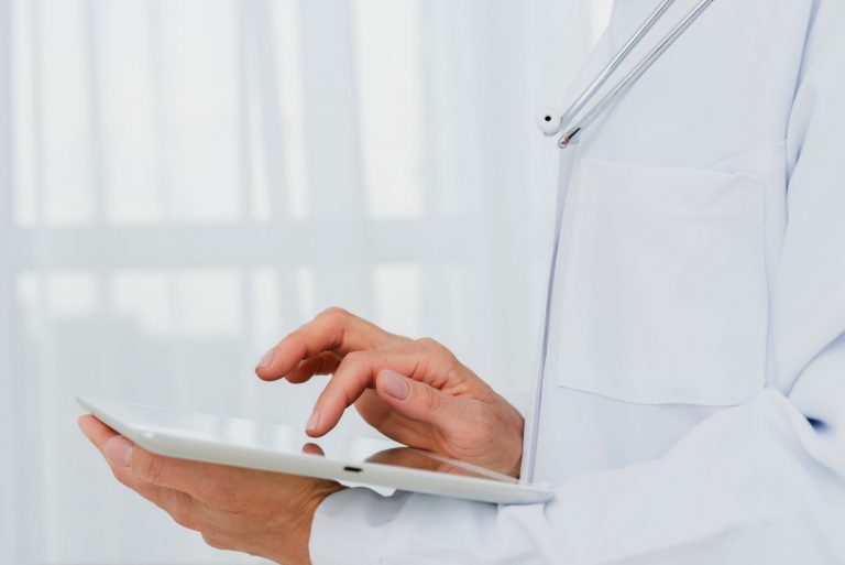 closeup doctor using tablet