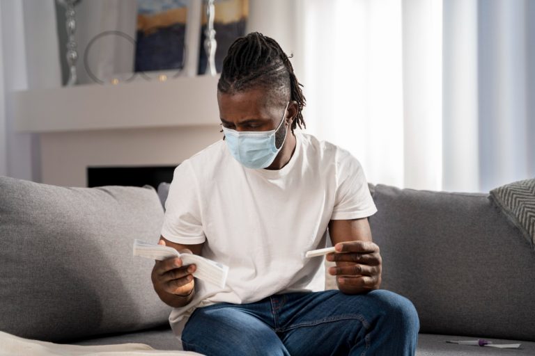 young man in a white shirt waiting for Covid test result