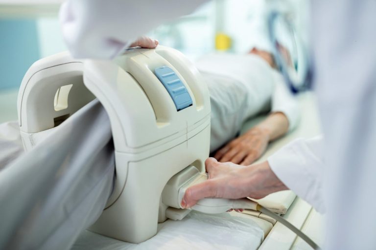 close up technician preparing patient knee MRI scan procedure clinic