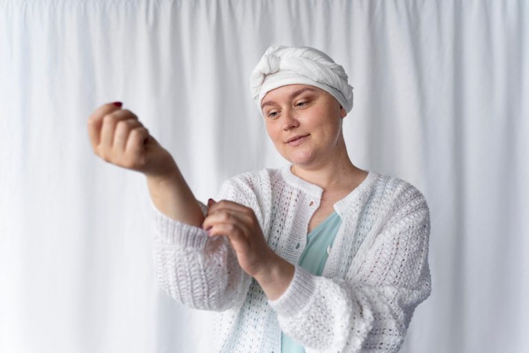 confident young woman fighting with cancer looking her arm and smiling