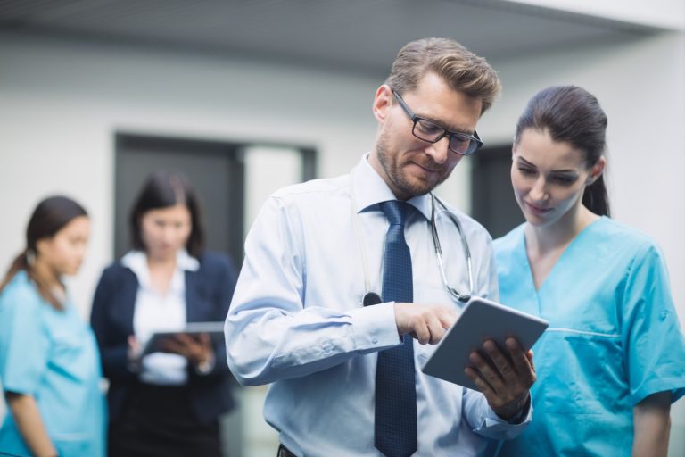doctor nurse discussing and watching tablet