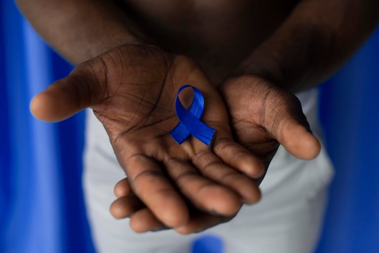 man holding blue ribbon in both hands